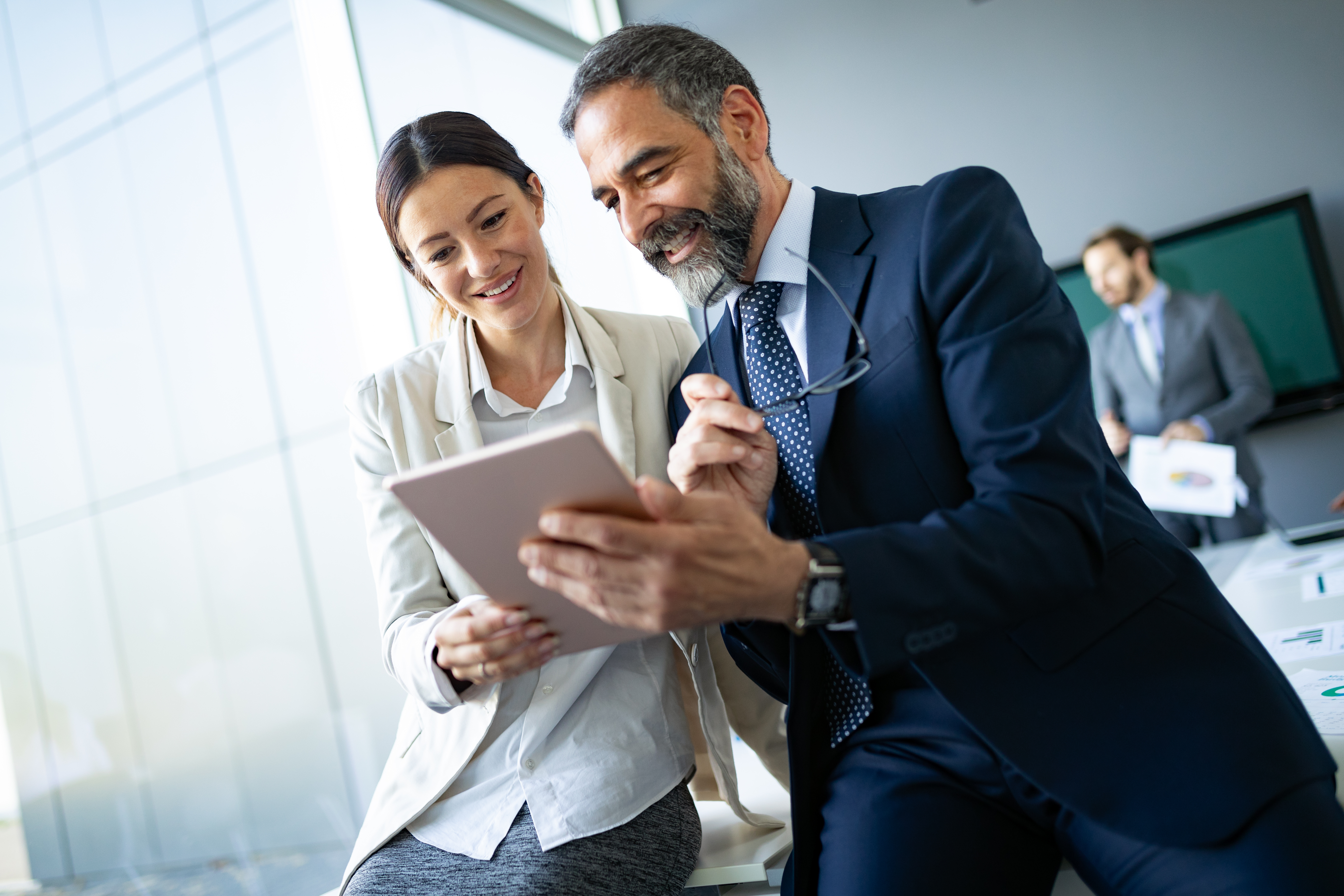 happy-business-colleagues-in-modern-office-using-tablet