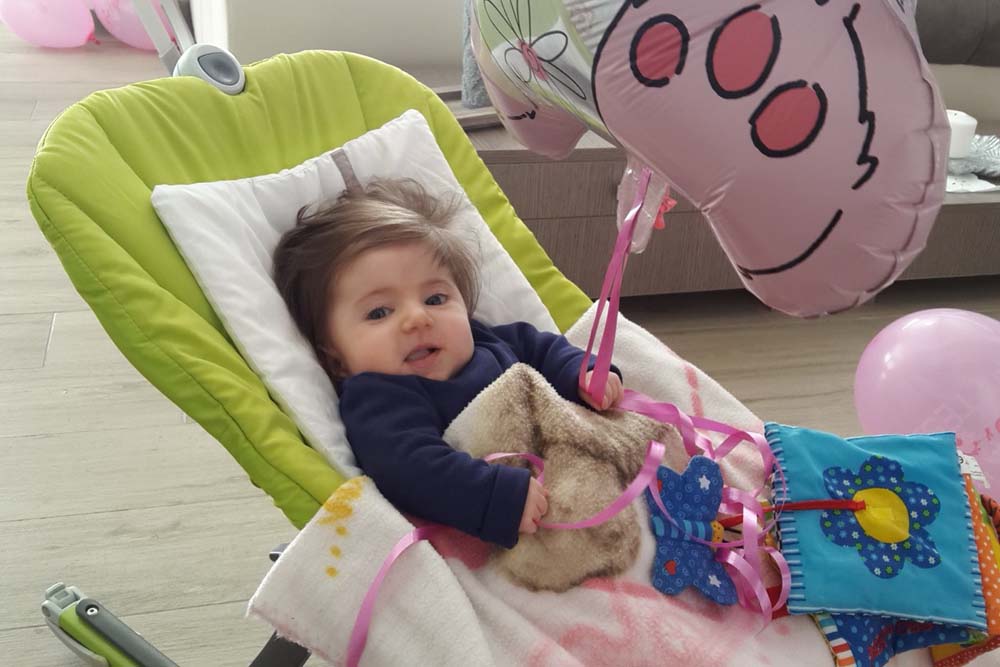 Eleonora da piccola, su una sediolina imbottita a causa dell'osteogenesi imperfetta